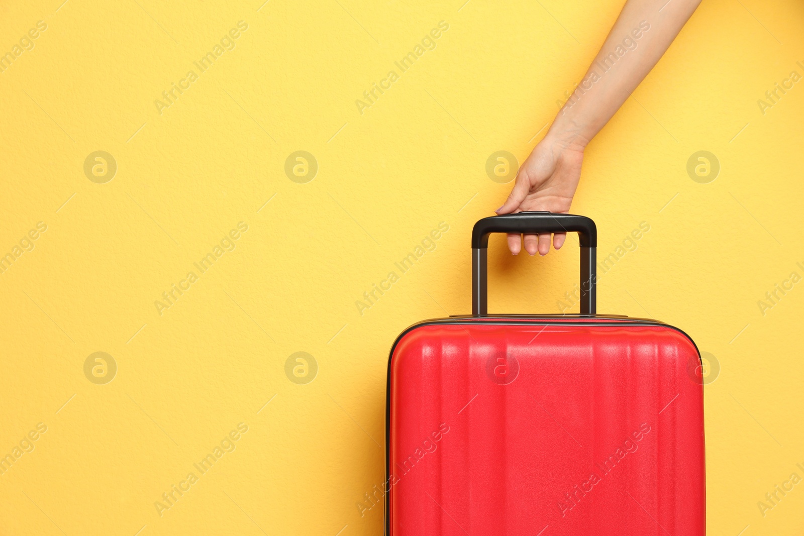 Photo of Woman with stylish suitcase against color background, closeup. Space for text