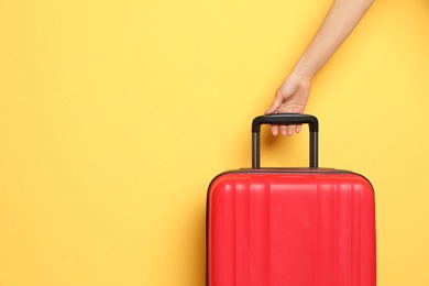 Woman with stylish suitcase against color background, closeup. Space for text