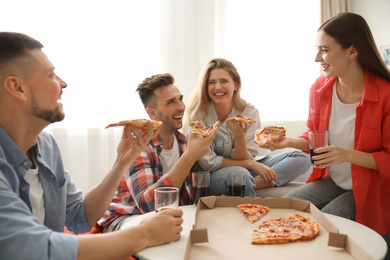 Group of friends eating tasty pizza at home