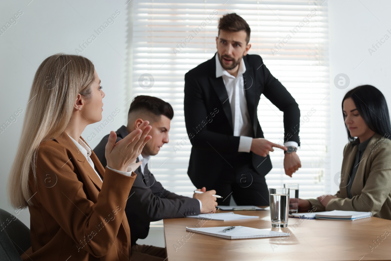 Photo of Businessman scolding employee for being late on meeting in office