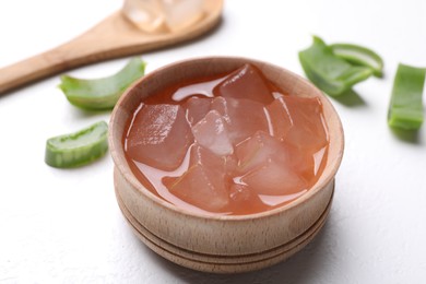 Aloe vera gel and slices of plant on white background, closeup