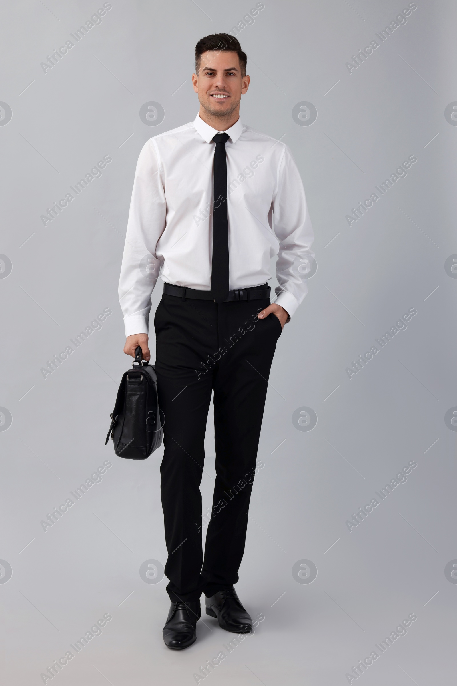 Photo of Businessman with stylish leather briefcase on light background