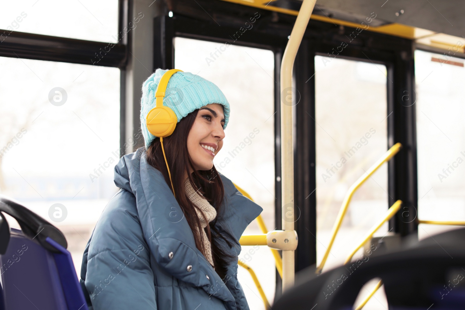 Photo of Young woman listening to music with headphones in public transport