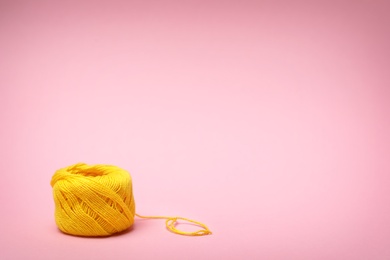 Yellow sewing thread on color background