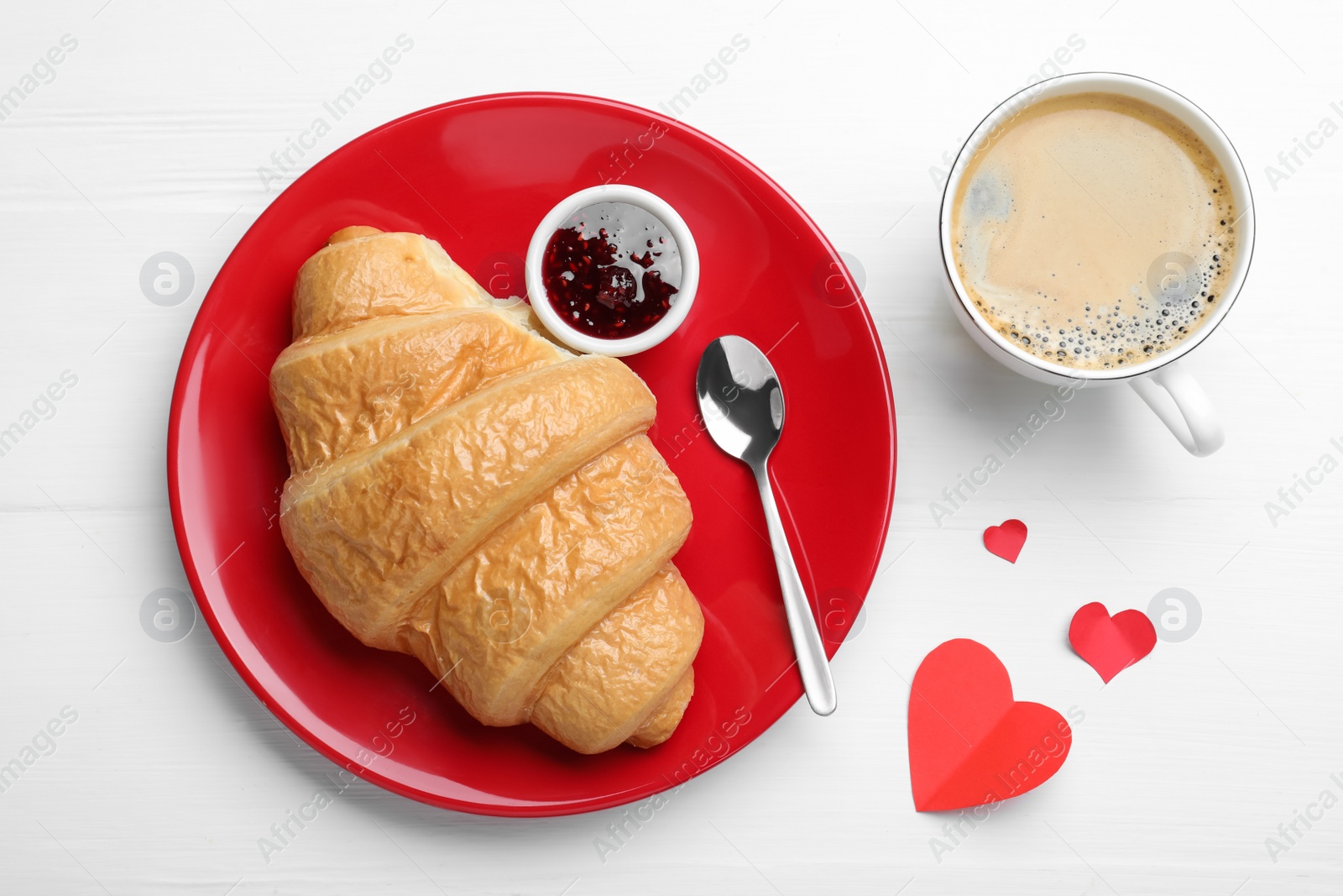 Photo of Cup of coffee, croissant and jam on white table, flat lay. Valentine's day breakfast