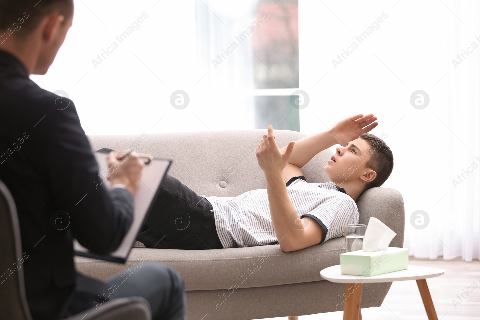 Photo of Psychotherapist working with young man in office