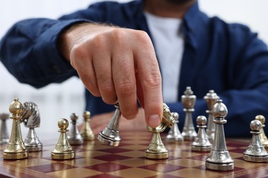 Photo of Man moving knight on chessboard, closeup view