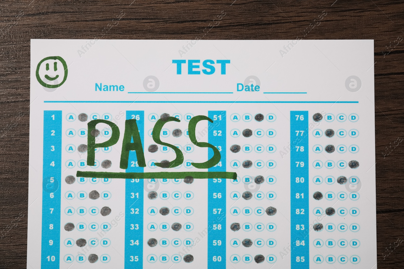 Photo of Answer sheet with word Pass on wooden table, top view. Student passing exam