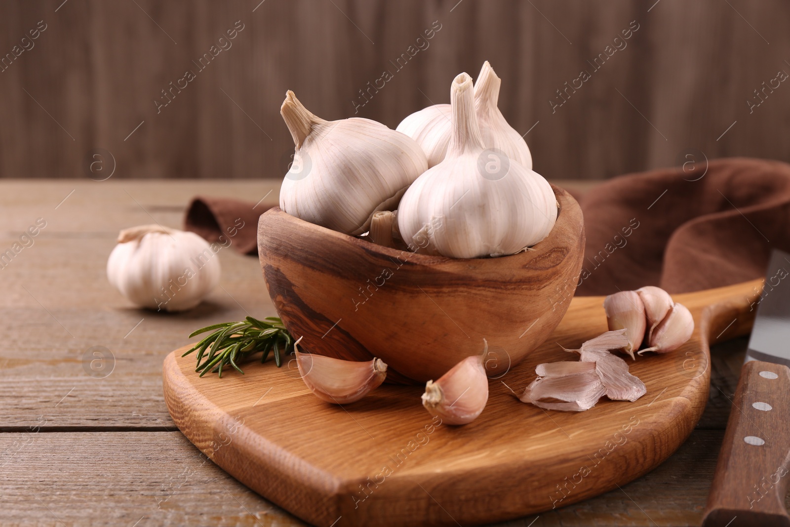 Photo of Fresh garlic and knife on wooden table, closeup. Space for text