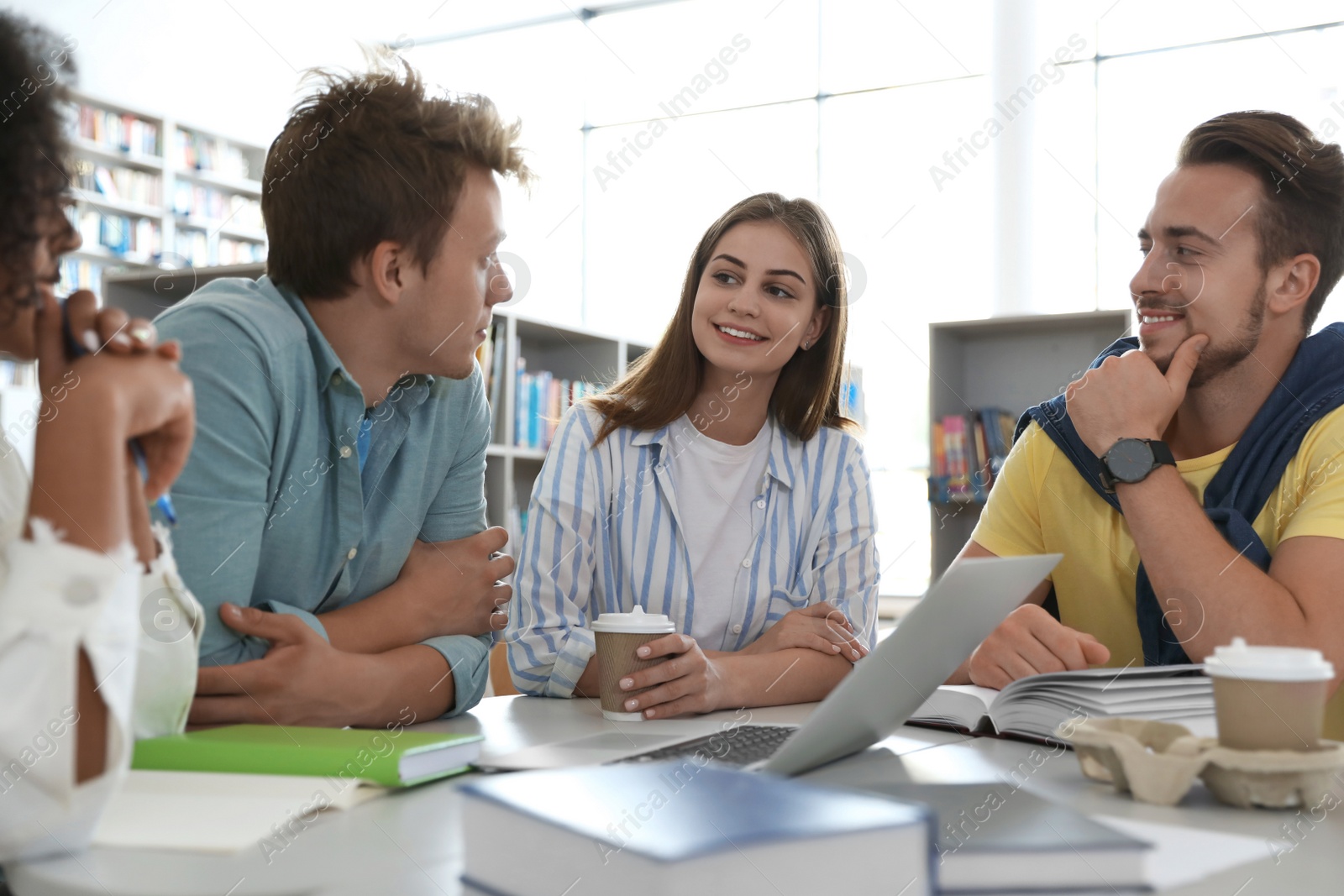 Photo of Group of young people studying at table in library