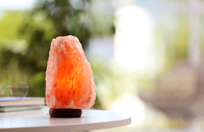 Photo of Himalayan salt lamp on table indoors, space for text