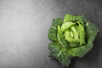 Photo of Fresh green savoy cabbage on grey table, top view. Space for text