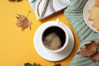 Photo of Flat lay composition with cup of hot drink on yellow background. Cozy autumn atmosphere