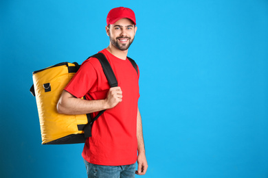 Photo of Courier with thermo bag on light blue background, space for text. Food delivery service