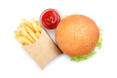 French fries, tasty burger and sauce on white background, top view