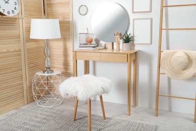 Photo of Modern wooden dressing table with mirror and stool in room