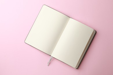 Photo of Blank notebook on pale pink background, top view