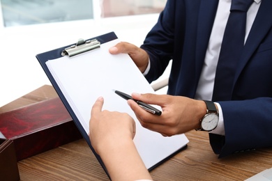 Photo of Male lawyer working with client at table, closeup