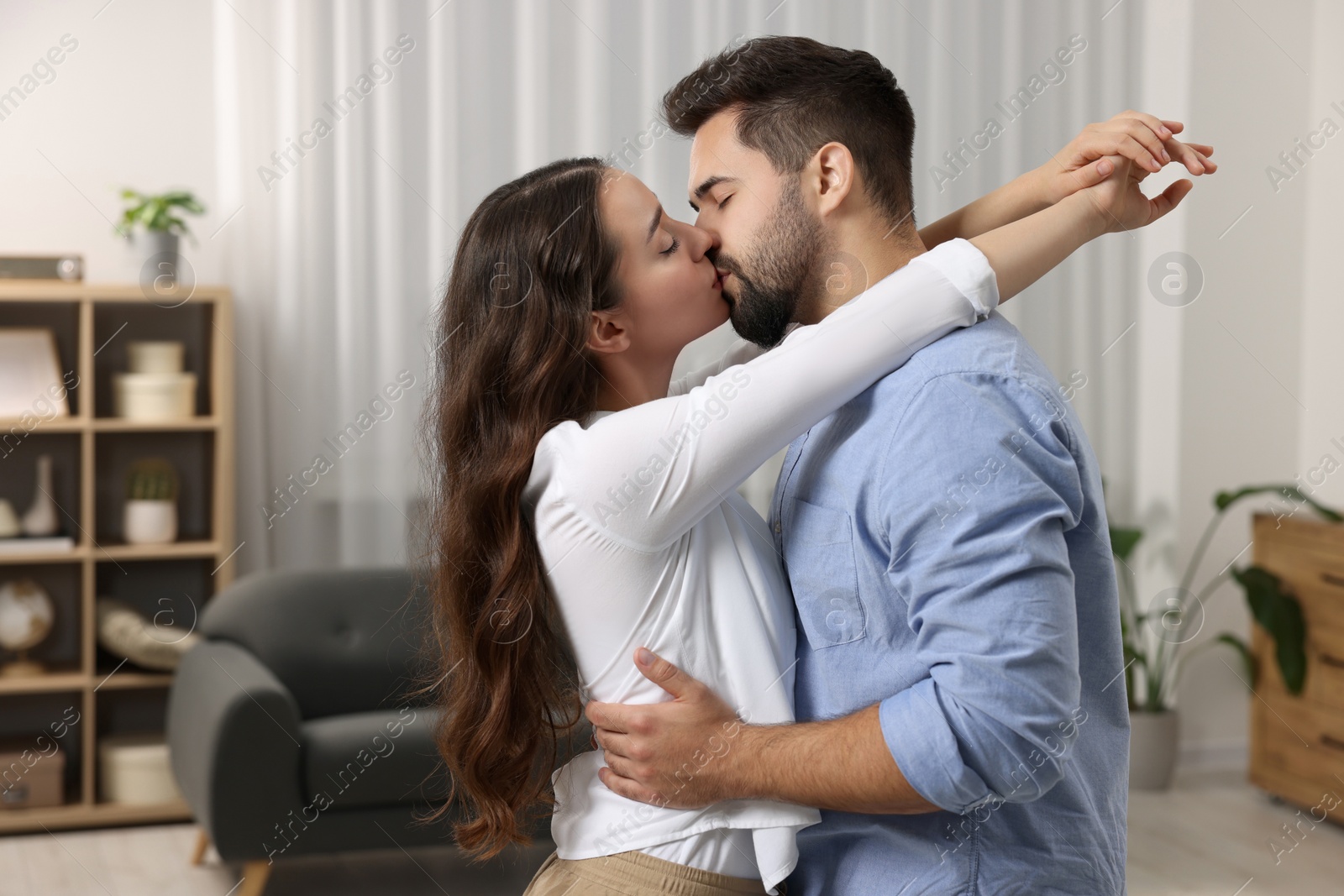 Photo of Love relationship. Passionate young couple kissing at home