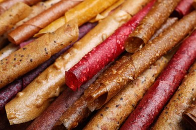 Photo of Delicious fruit leather rolls as background, closeup