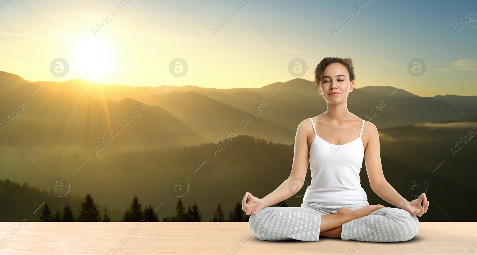 Image of Young African American woman practicing yoga on wooden surface against beautiful mountain landscape, space for text. Banner design