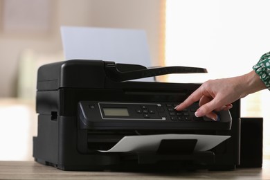 Photo of Woman using modern printer in office, closeup