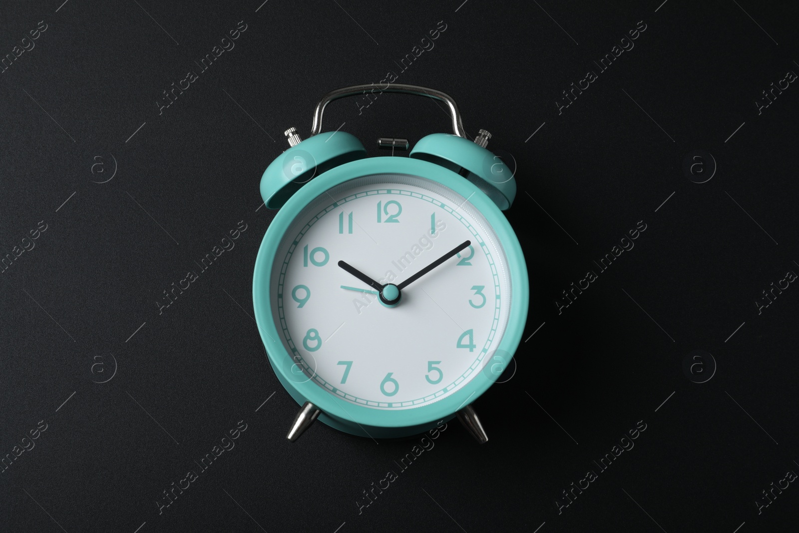 Photo of Alarm clock on black background, above view. School time