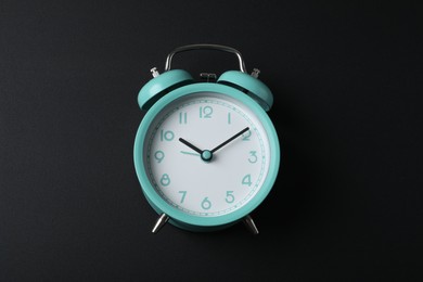 Photo of Alarm clock on black background, above view. School time