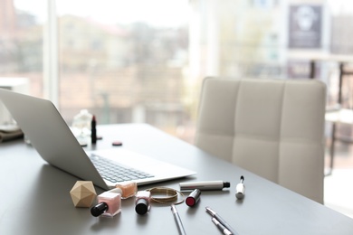 Photo of Makeup products for woman and laptop on table