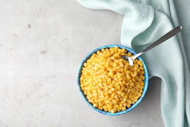 Flat lay composition with corn kernels in bowl on grey background. Space for text