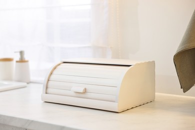 Wooden bread box on white countertop in kitchen