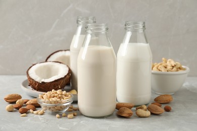 Photo of Different nut milks on light grey marble table