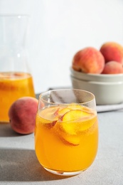 Photo of Tasty peach cocktail on table. Refreshing drink