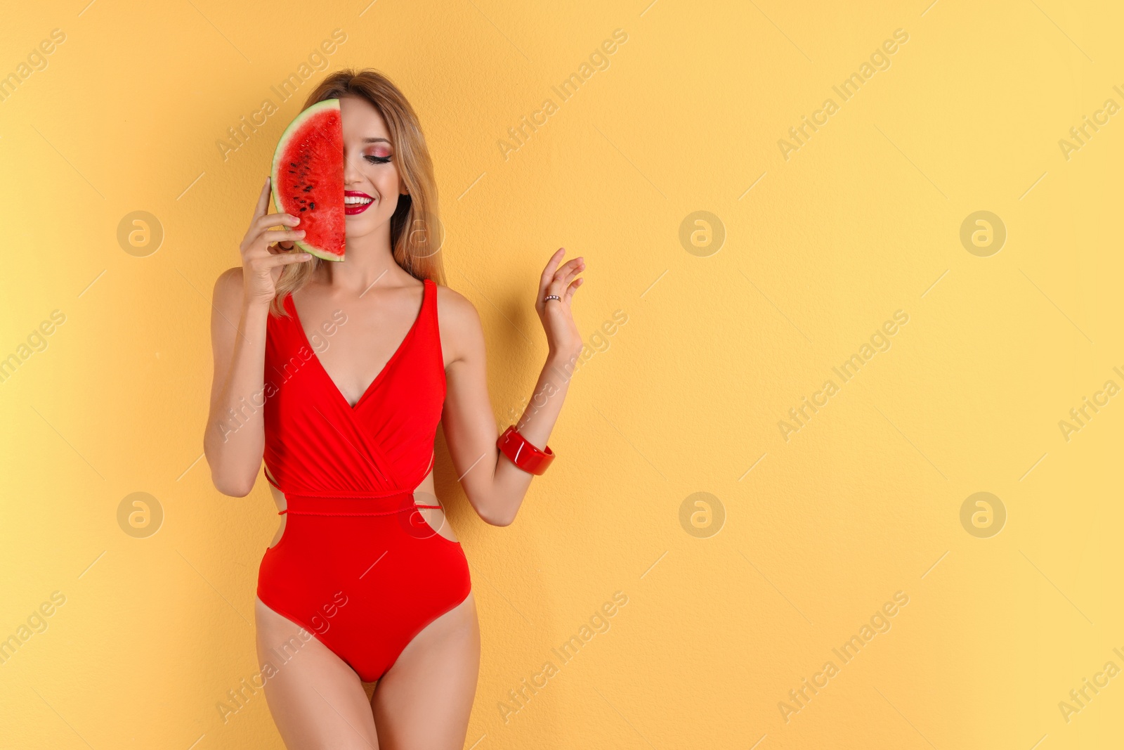 Photo of Pretty young woman with juicy watermelon on color background