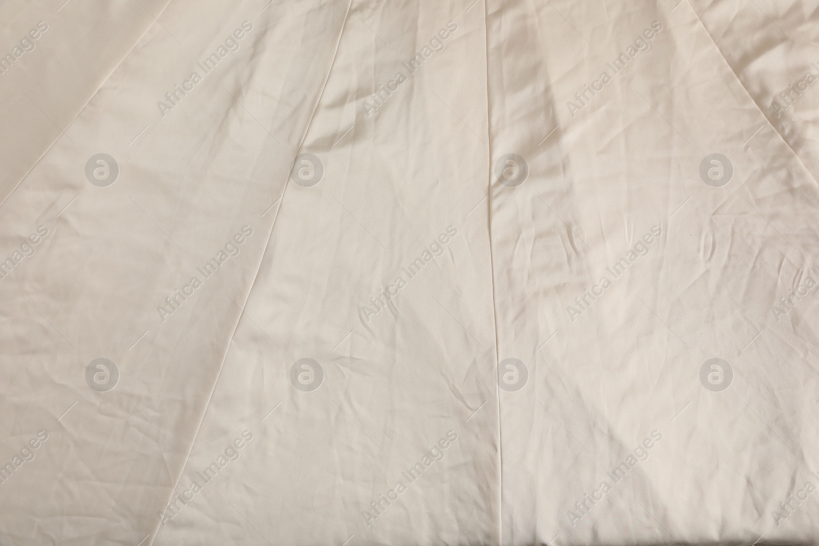 Photo of Crumpled beige fabric as background, closeup view