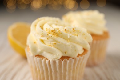 Photo of Tasty cupcake with cream and lemon zest on table, closeup