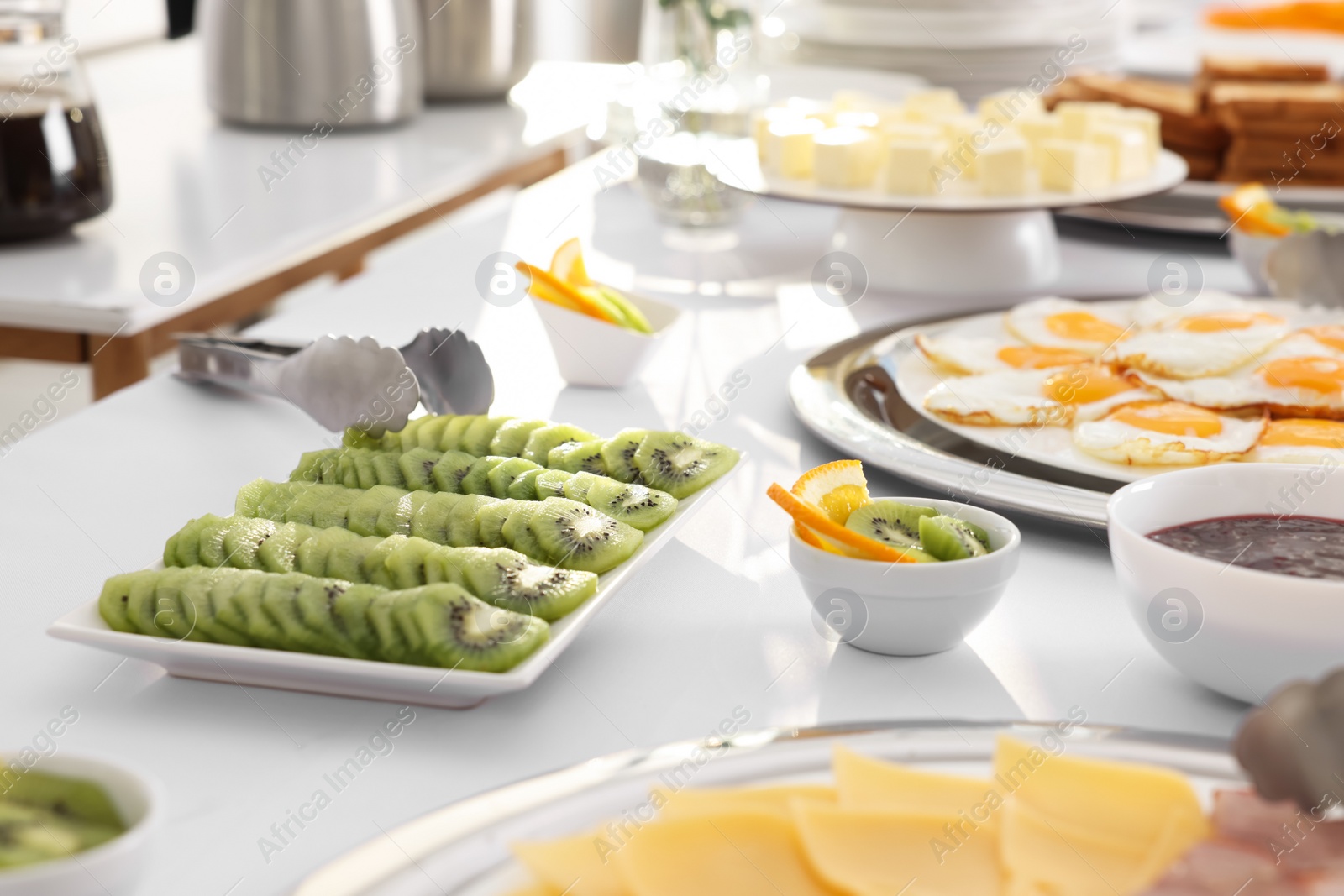 Photo of Different meals for breakfast on white table indoors. Buffet service