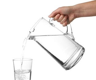 Woman pouring water from jug into glass on white background, closeup