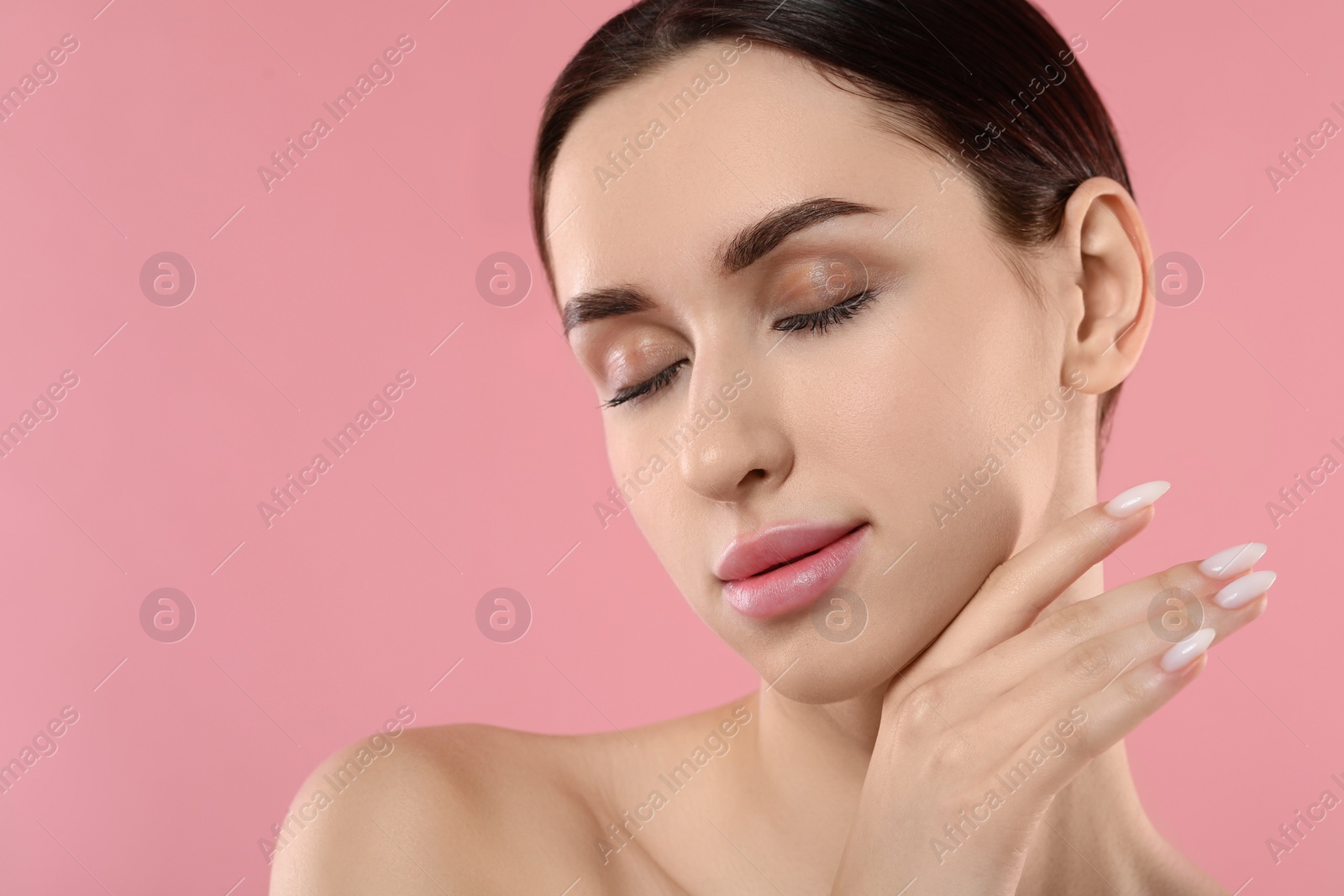 Photo of Portrait of beautiful young woman on pink background