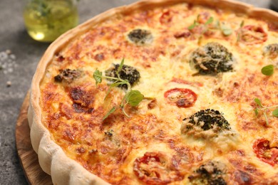 Delicious homemade vegetable quiche on gray table, closeup