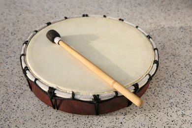 Photo of Drum and drumstick on grey table, closeup. Percussion musical instrument