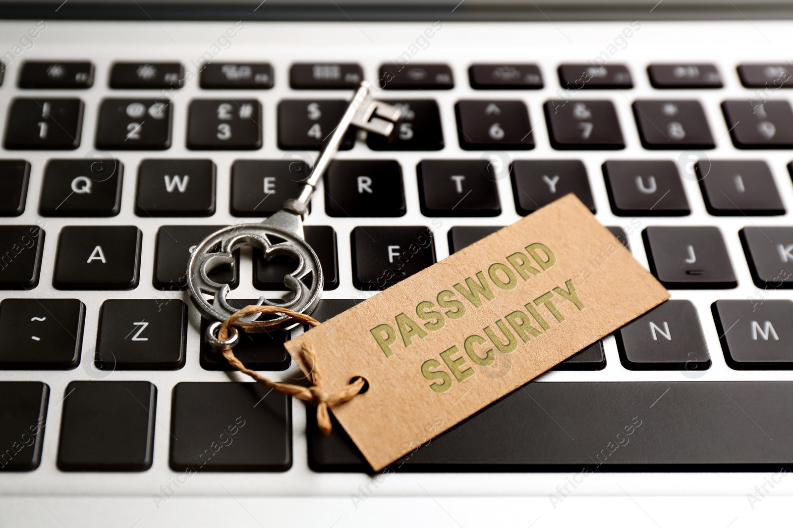 Image of Key with tag PASSWORD SECURITY on laptop keyboard, closeup