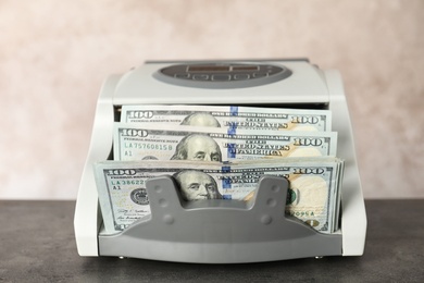 Photo of Modern bill counter with money on table