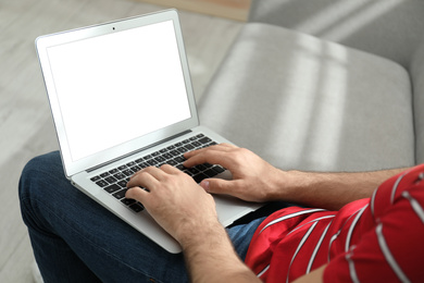 Photo of Man working on modern laptop at home, closeup