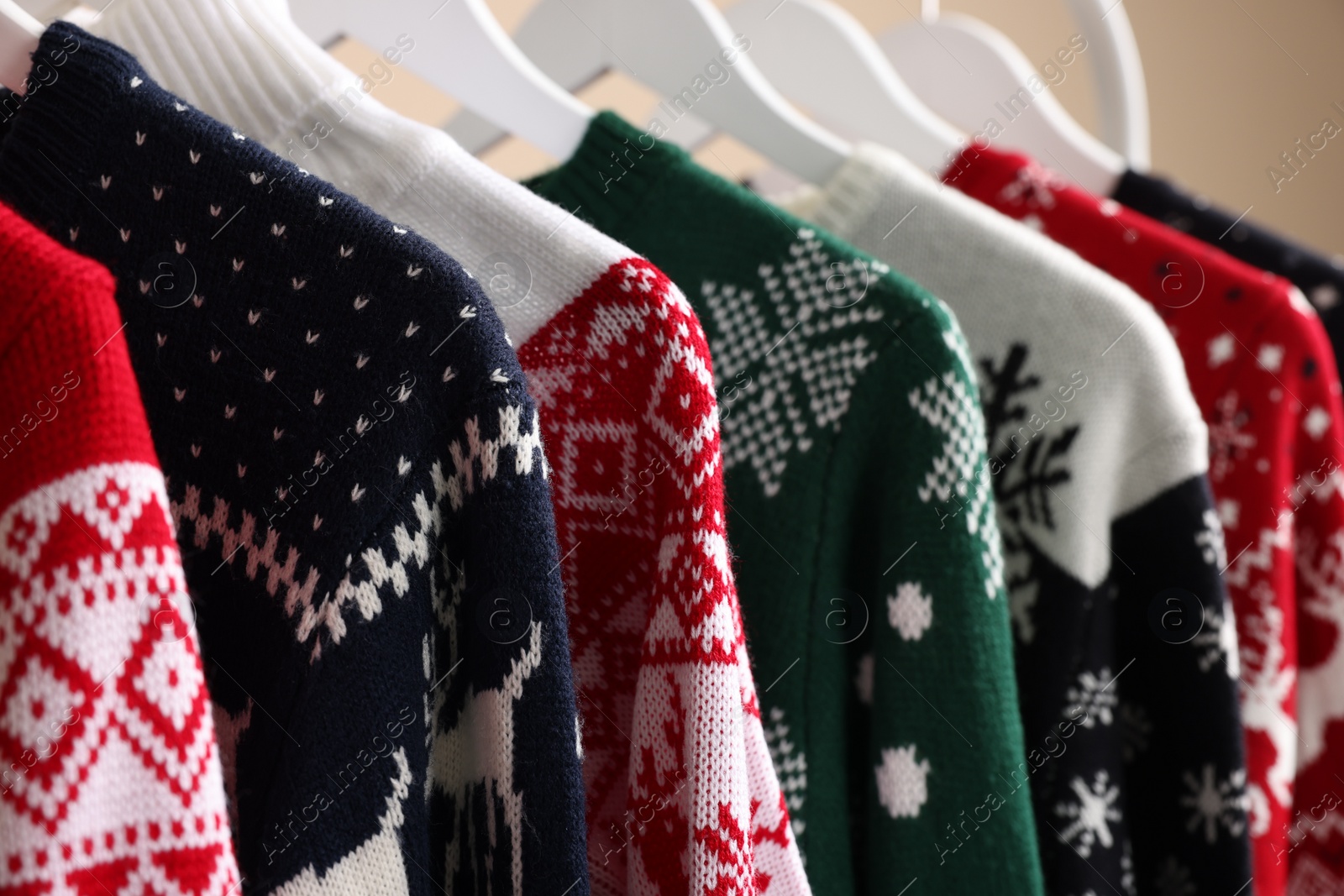 Photo of Rack with different Christmas sweaters, closeup view