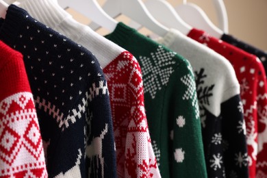 Rack with different Christmas sweaters, closeup view