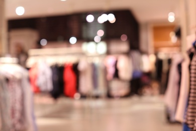 Photo of Blurred view of modern store with different clothes