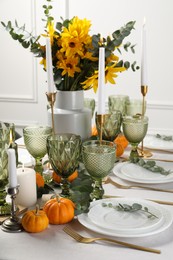 Photo of Beautiful autumn table setting with bouquet indoors. Plates, cutlery, glasses and floral decor