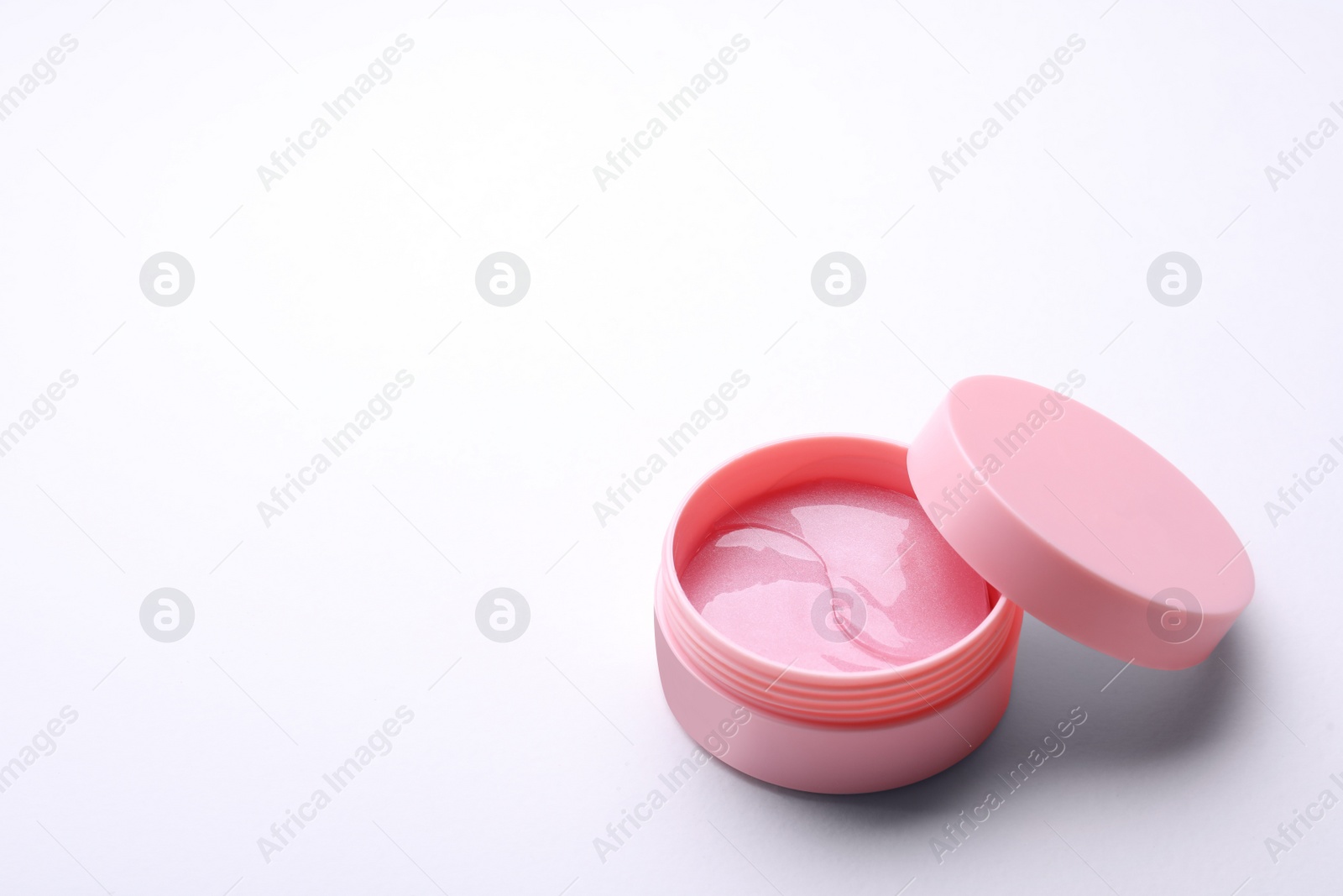 Photo of Under eye patches in jar with lid isolated on white. Cosmetic product