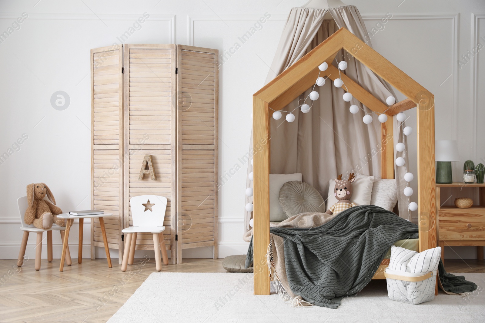 Photo of Stylish child room interior with wooden house bed